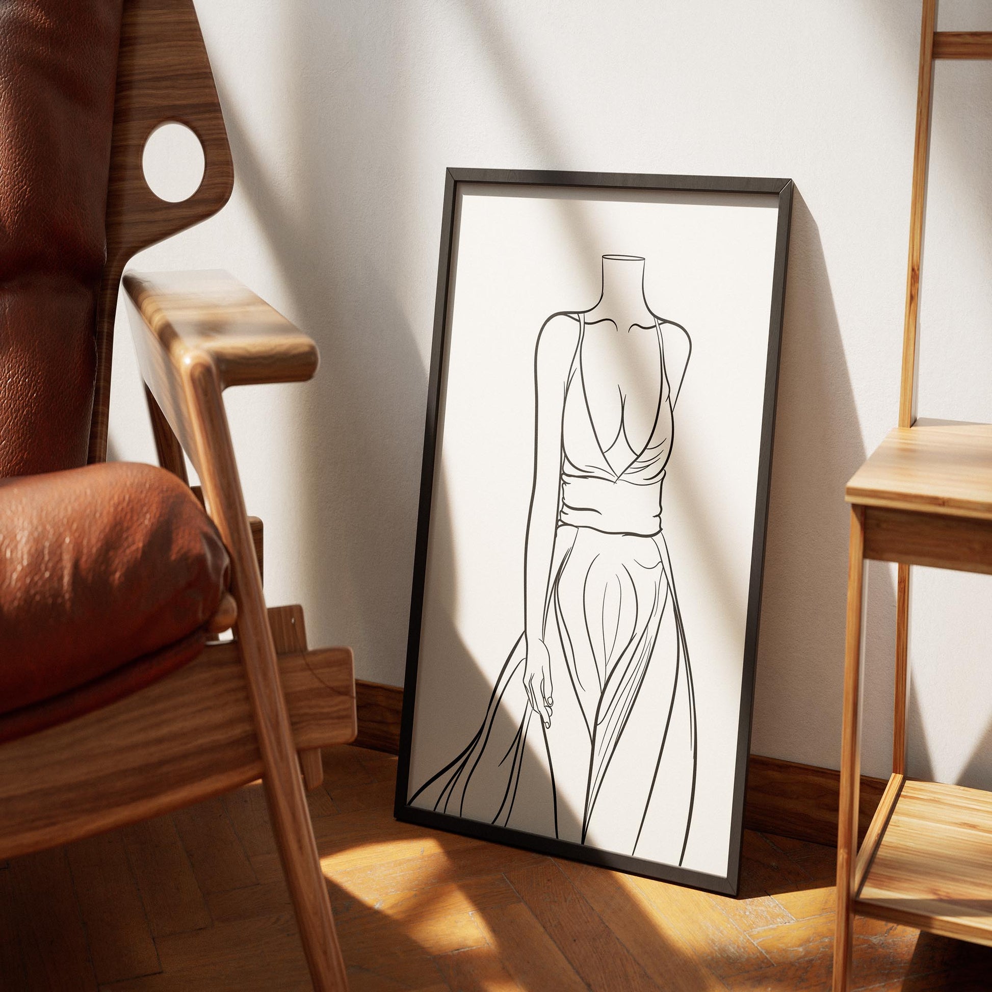 Line art illustration of a flowing gown, framed and leaning against a wall next to a wooden chair.